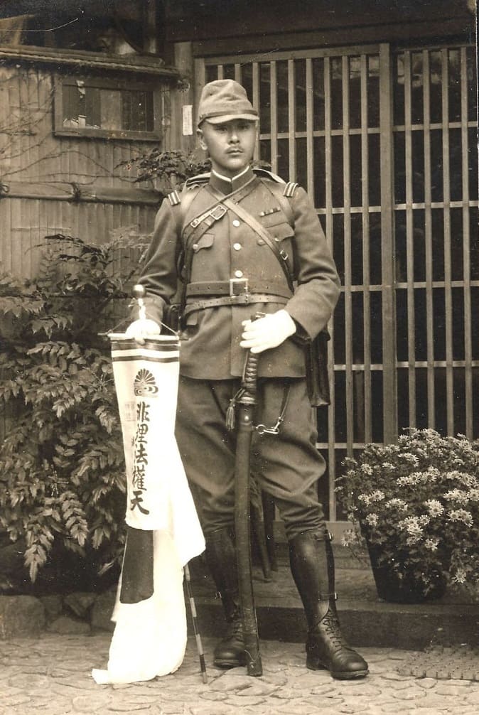 Captain holds a banner with Kikusui symbol.jpg